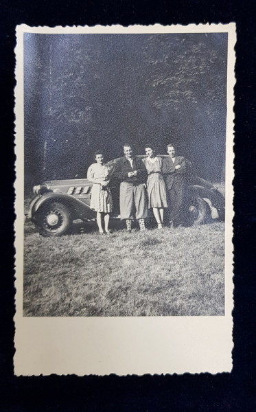 DOUA CUPLURI POZAND LANGA UN AUTOMOBIL DE EPOCA , FOTOGRAFIE TIP CARTE POSTALA , PE HARTIE CERATA , MONOCROMA, DATATA AUGUST 1942