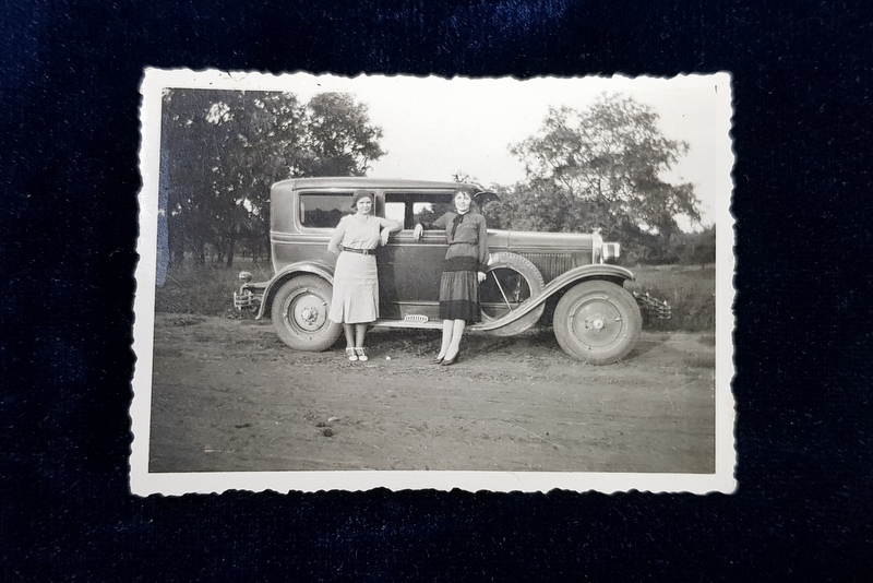 DOUA TINERE POZAND LANGA AUTOMOBIL , FOTOGRAFIE MONOCROMA, FORMAT MIC , PERIOADA INTERBELICA