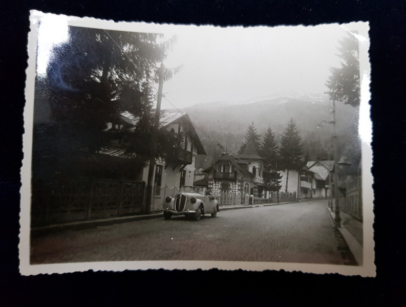 MASINA DECAPOTABILA PE O STRADA A UNUI ORAS DE LANGA MUNTII BUCEGI , FOTOGRAFIE MONOCROMA, PE HARTIE LUCIOASA , PERIOADA INTERBELICA