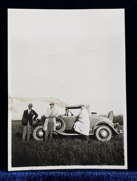 TREI DOMNI POZAND LANGA UN AUTOMOBIL DE EPOCA , IN CAMP , FOTOGRAFIE MONOCROMA, PE HARTIE CRETATA , PERIOADA INTERBELICA , DEGRADATA PE PARTEA STANGA *