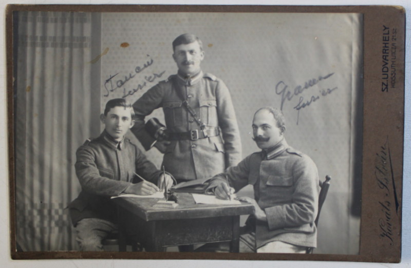 TREI MILITARI LA BIROU DE LUCRU , POZAND IN STUDIO , FOTOGRAFIE TIP CABINET , MONOCROMA, LIPITA PE CARTON , DATATA PE VERSO 1919